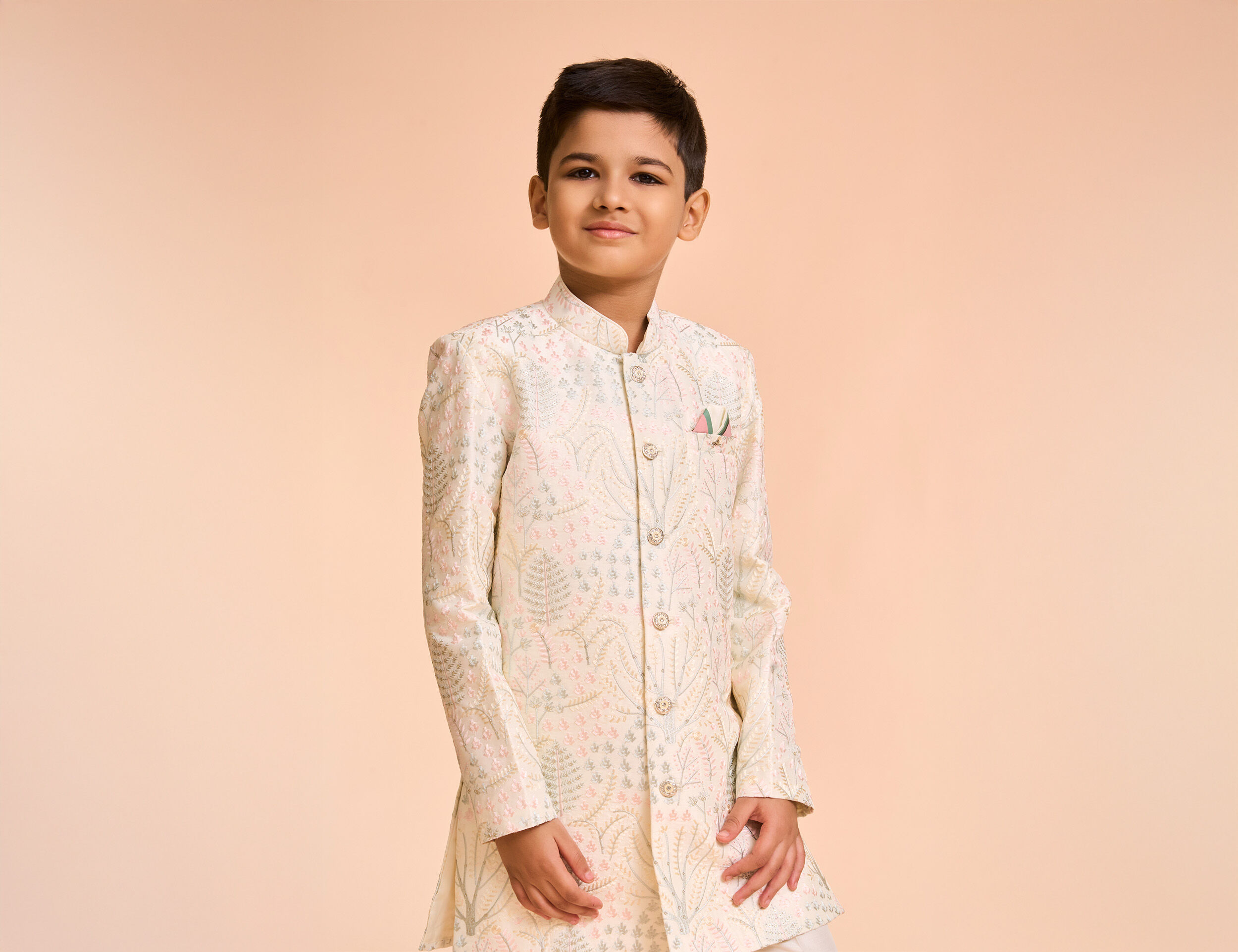 A boy wearing white pattern indo western sherwani for wedding celebration
